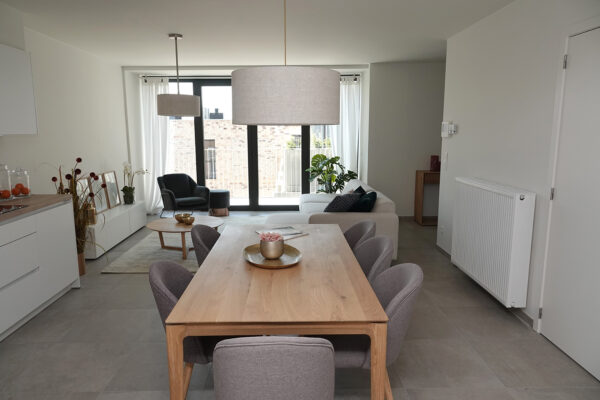 De eetkamer van een assistentiewoning in Angelahof, gelegen in Diepenbeek, biedt zitplaatsen voor zes personen. Door de open indeling gaan de eet- en zitruimte naadloos in elkaar over, wat een ruime en lichte sfeer creëert.