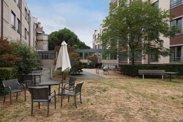 De tuin van woonzorgcentrum Bellevue, gelegen naast de petanquebaan en het terras, en omringd door het gebouw.