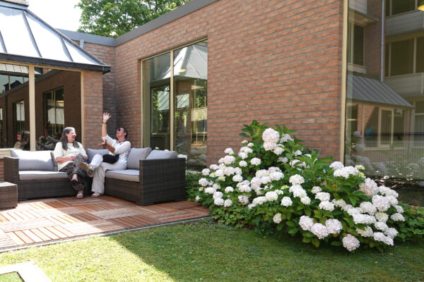 Les Pléiades - Jardin - 2 personnes assises sur un canapé - Maison de repos - Woluwe St Lambert