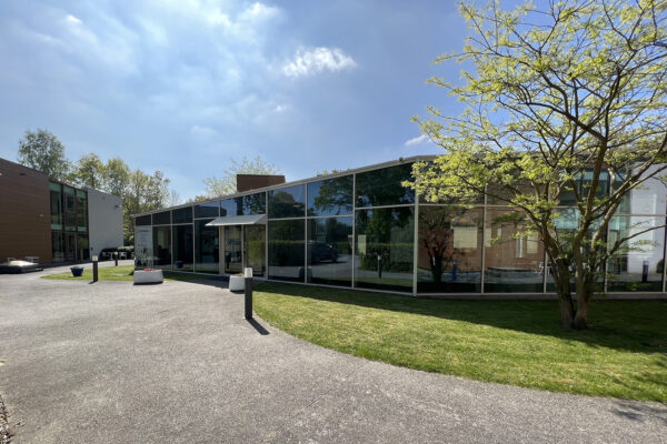 De ingang naar het restaurant op de campus van Ter Bleuk. Het gebouw heeft glazen gevels en is voor iedereen toegankelijk.