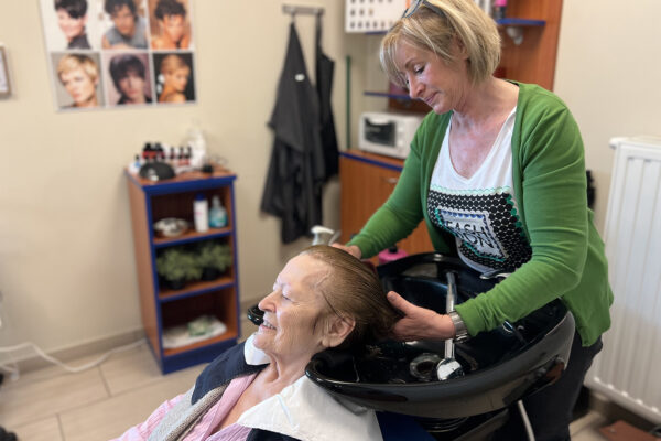 Het kapsalon waar elke bewoner van de assistentiewoningen Ter Bleuk hun haar kan laten knippen en/of wassen. De kapper is bezig met het wassen van het haar van een bewoner.