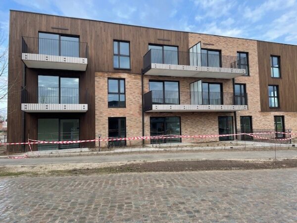 Een duidelijk uitzicht op de gevel van woonzorgcentrum De Ravestein, waar te zien is dat de kamers beschikken over persoonlijke terrassen.