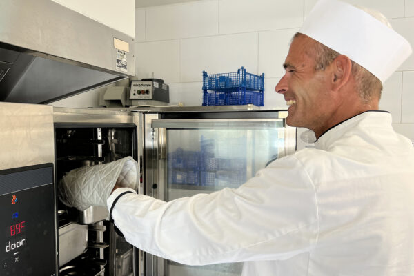 Le Cocon Cuisine chef coq devant le four Résidence neuropsychiatrique - Namur