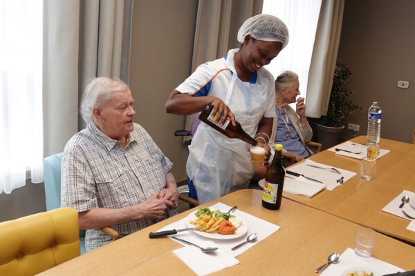 Héris - Restaurant avec groupe de personnes repas et verre de bière à table maison de repos - Soignies