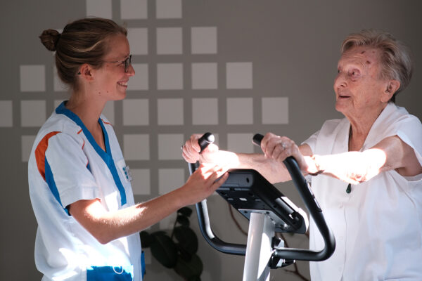 Le Parc - Salle kiné avec femme âgée sur un vélo d'appartement - maison de repos - Nivelles
