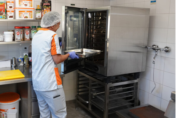 Les Récollets - Cuisine avec une personne qui entre le plat dans le four - maison de repos - Buvrinnes
