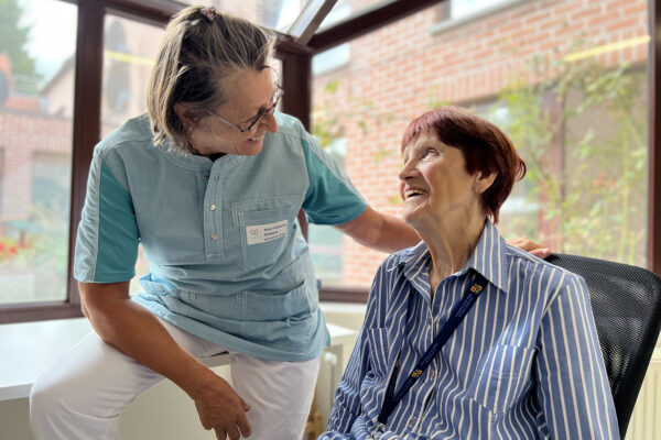 Les Sittelles - Conversation entre 2 personnes avec une baie vitrée en arrière- plan - Maison de repos - Chastre