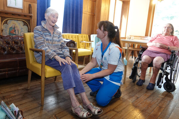Les Jardins d'Astrid- une kiné aide à lever les jambes - Maison de repos Maurage