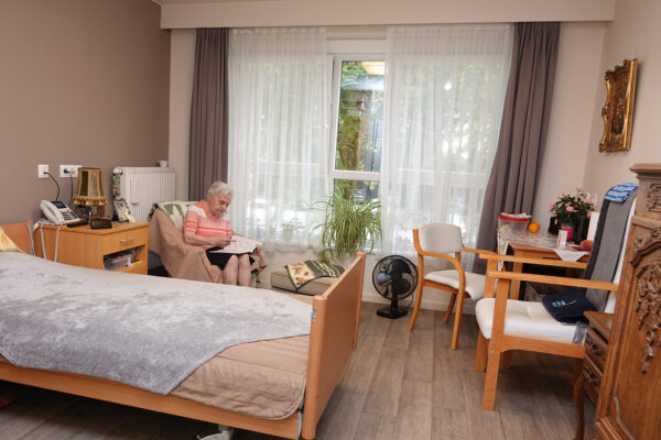 Les Jardins d'Astrid maison de repos - Chambre avec une dame qui lit - Maurage