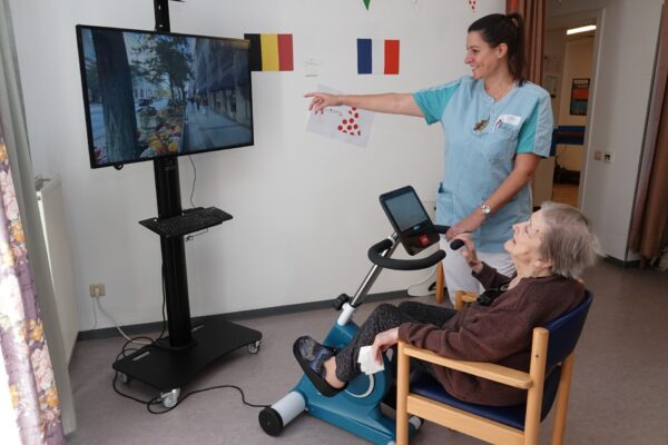 Golden Morgen- Salle kiné une dame âgée pédale sur un vélo d'appartement - maison de repos - Lontzen
