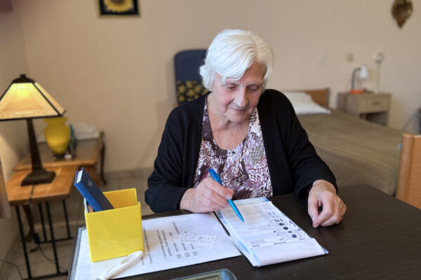 Le Colvert- Chambre avec une femme âgée assise à une table qui lit - maison de repos - Céroux Mousty