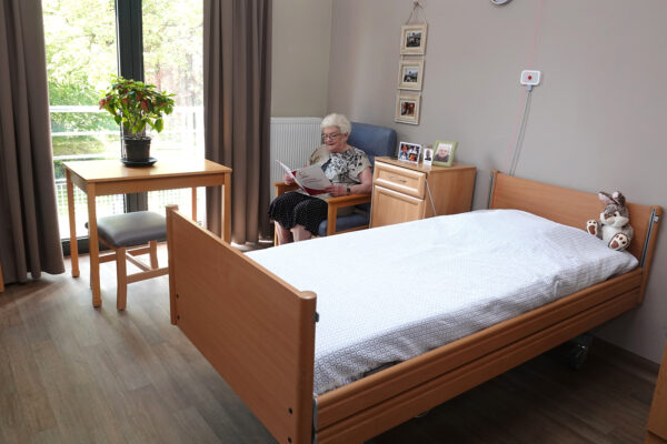 Les Jours Heureux - Chambre 1 lit avec une femme qui lit - maison de repos - Charleroi