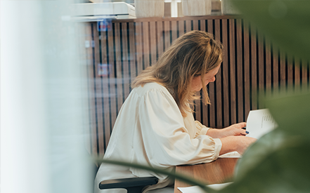 Verpleegkundige denkt na over de toekomst en het laten overnemen van de thuisverplegingspraktijk, ze bladert door de informatiebrochure.